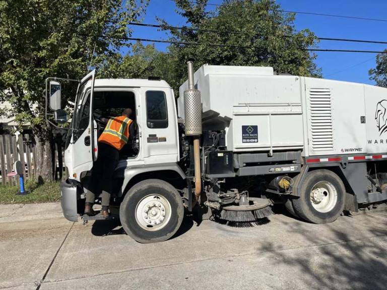 Worker and street sweeper